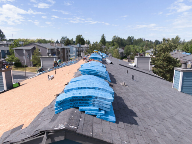 Packaged shingles sitting on top of a half-finished roof