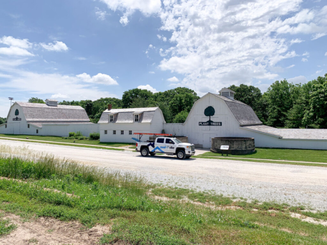 White barns on a gravel road with new roofing