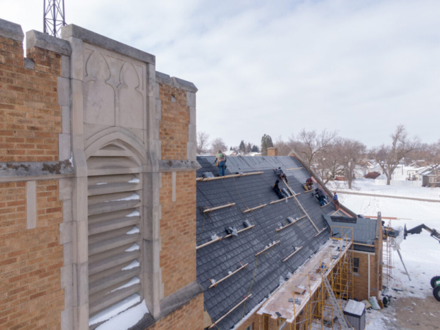 A church in the progress of being re-roofed with snow on the ground
